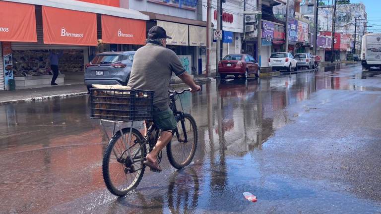 Miles de litros de agua corren por la calle Aquiles Serdán en el Centro de Mazatlán.