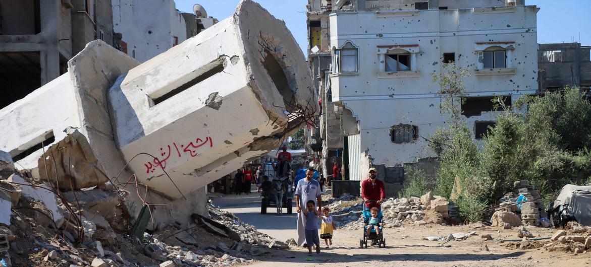 $!Una familia pasa frente a una mezquita destruida en Gaza.