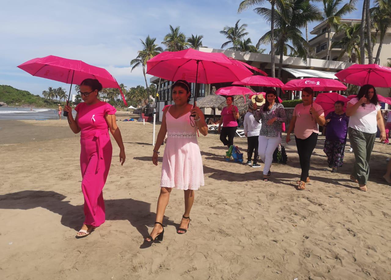 $!Las damas recibieron un paraguas rosa que utilizaron para una sesión de fotos en la playa.