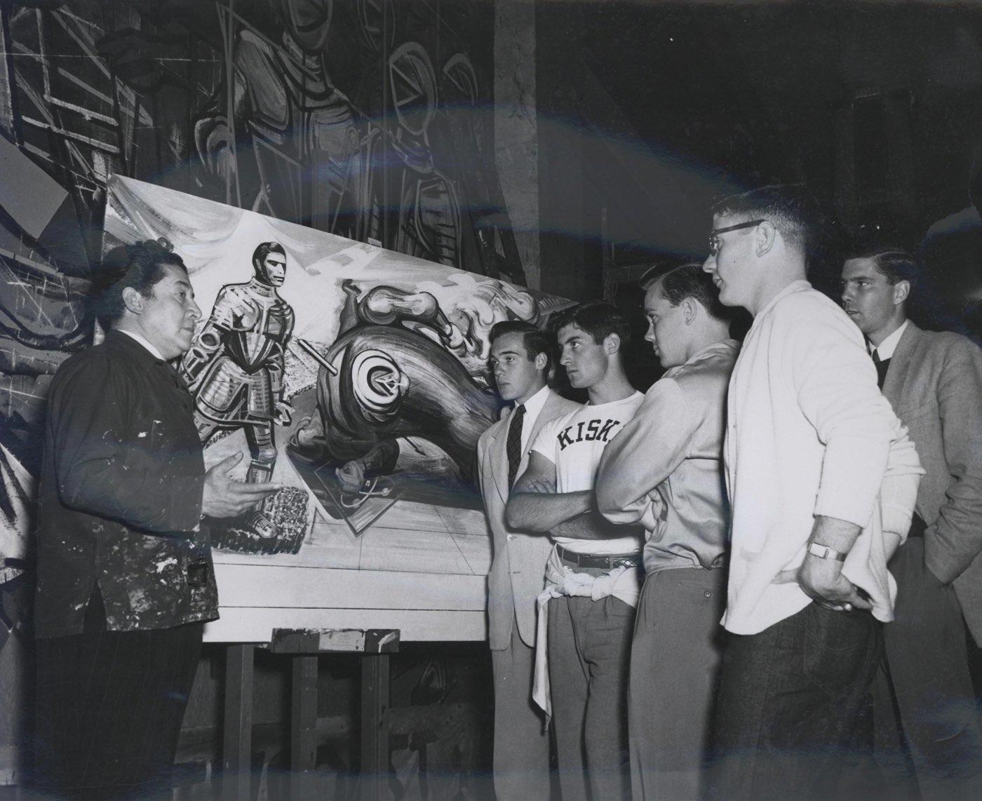 $!David Alfaro Siqueiros explicando el boceto del mural, Apoteosis de Cuauhtémoc a un grupo de jóvenes norteamericanos en el Palacio de Bellas Artes.