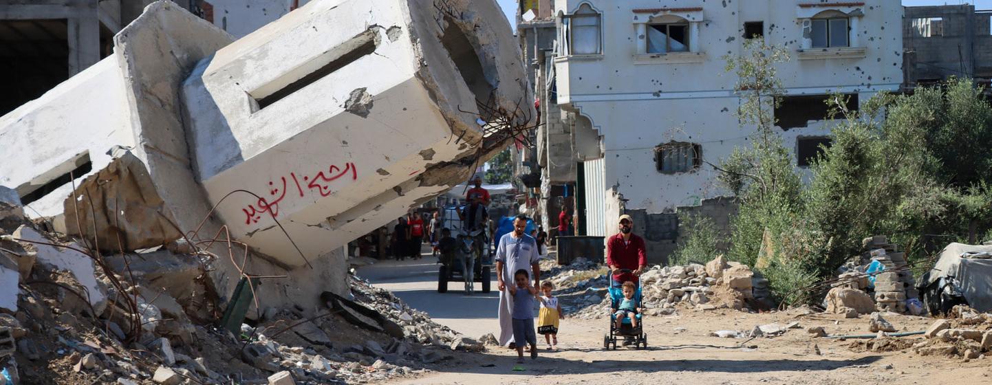 $!Una familia pasa frente a una mezquita destruida en Gaza.