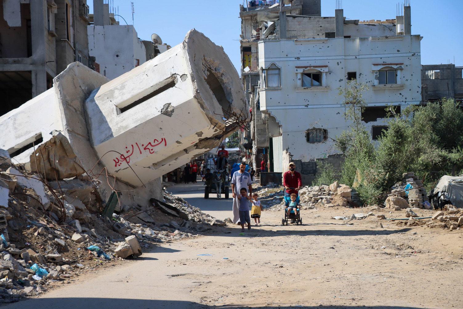 $!Una familia pasa frente a una mezquita destruida en Gaza.