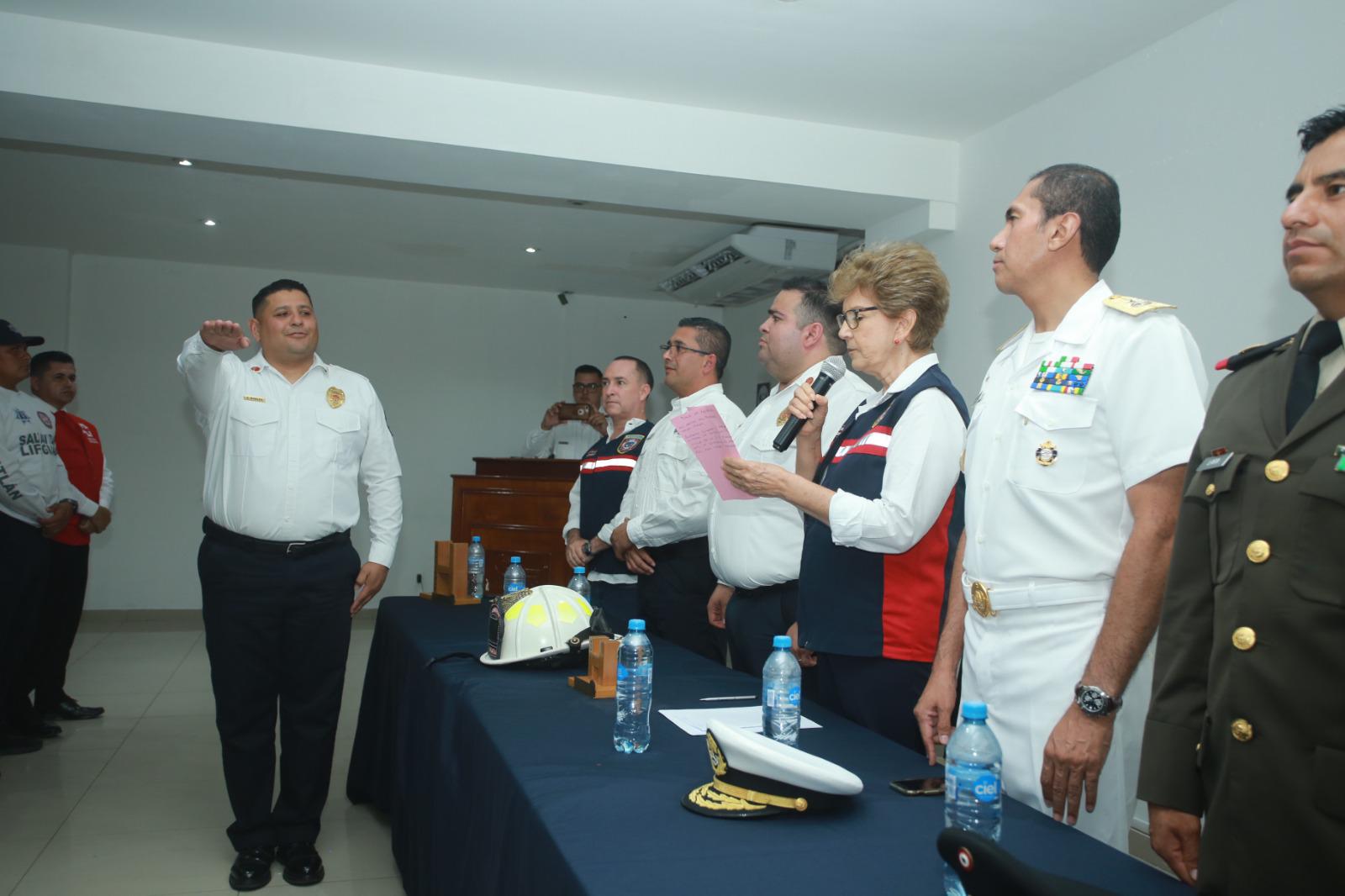 $!La presidenta del Patronato del H. Cuerpo Voluntarios de Bomberos Mazatlán, María Lourdes Magallón Huerta, le toma la protesta a Saúl Robles como nuevo titular de la corporación.