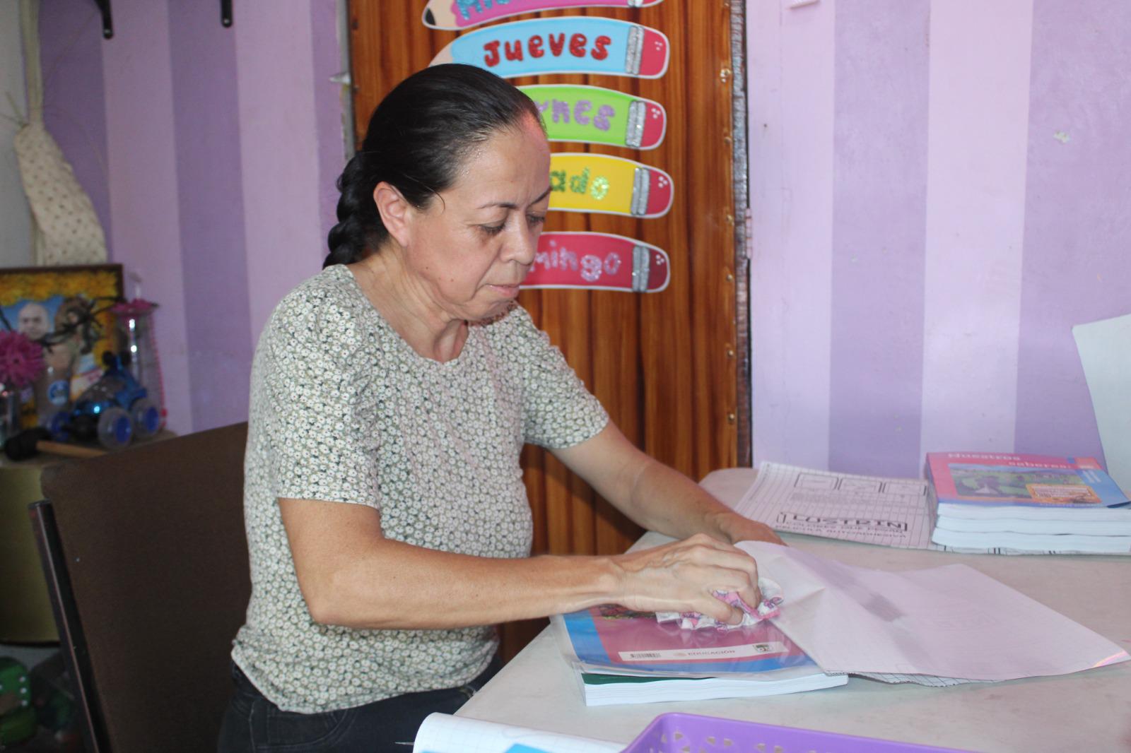 $!Lucía, con paciencia, en el regreso a clases hace del forrado de libros un oficio