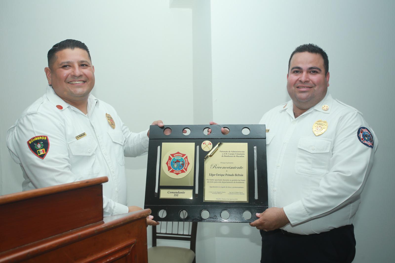 $!Saúl Robles, nuevo titular de Bomberos Voluntarios de Mazatlán, entrega reconocimiento a Édgar Peinado Beltrán.