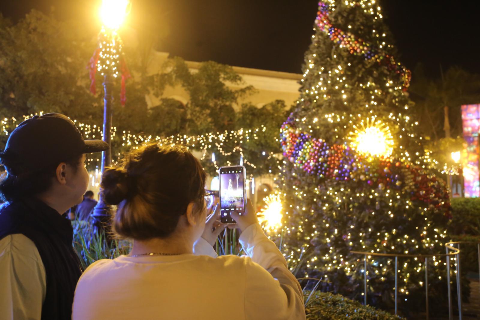 $!Los asistentes tuvieron la oportunidad de tomar la fotografía del recuerdo al pino de Navidad que fue ilumninado.