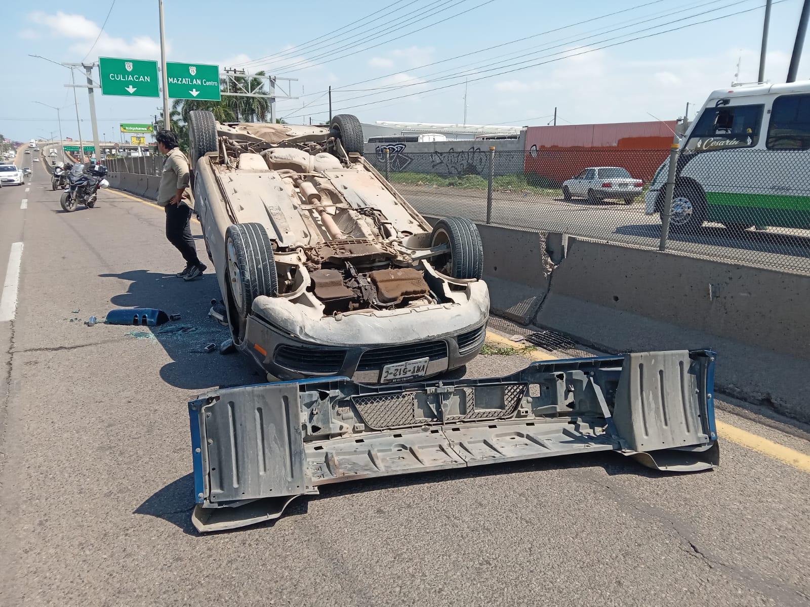 $!Auto vuelca tras chocar contra muro y tráiler que maniobraba en el sur de Mazatlán