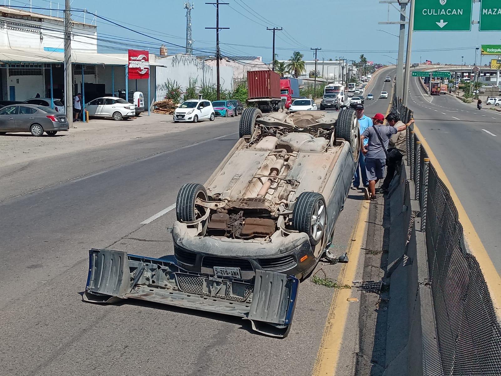 $!Auto vuelca tras chocar contra muro y tráiler que maniobraba en el sur de Mazatlán