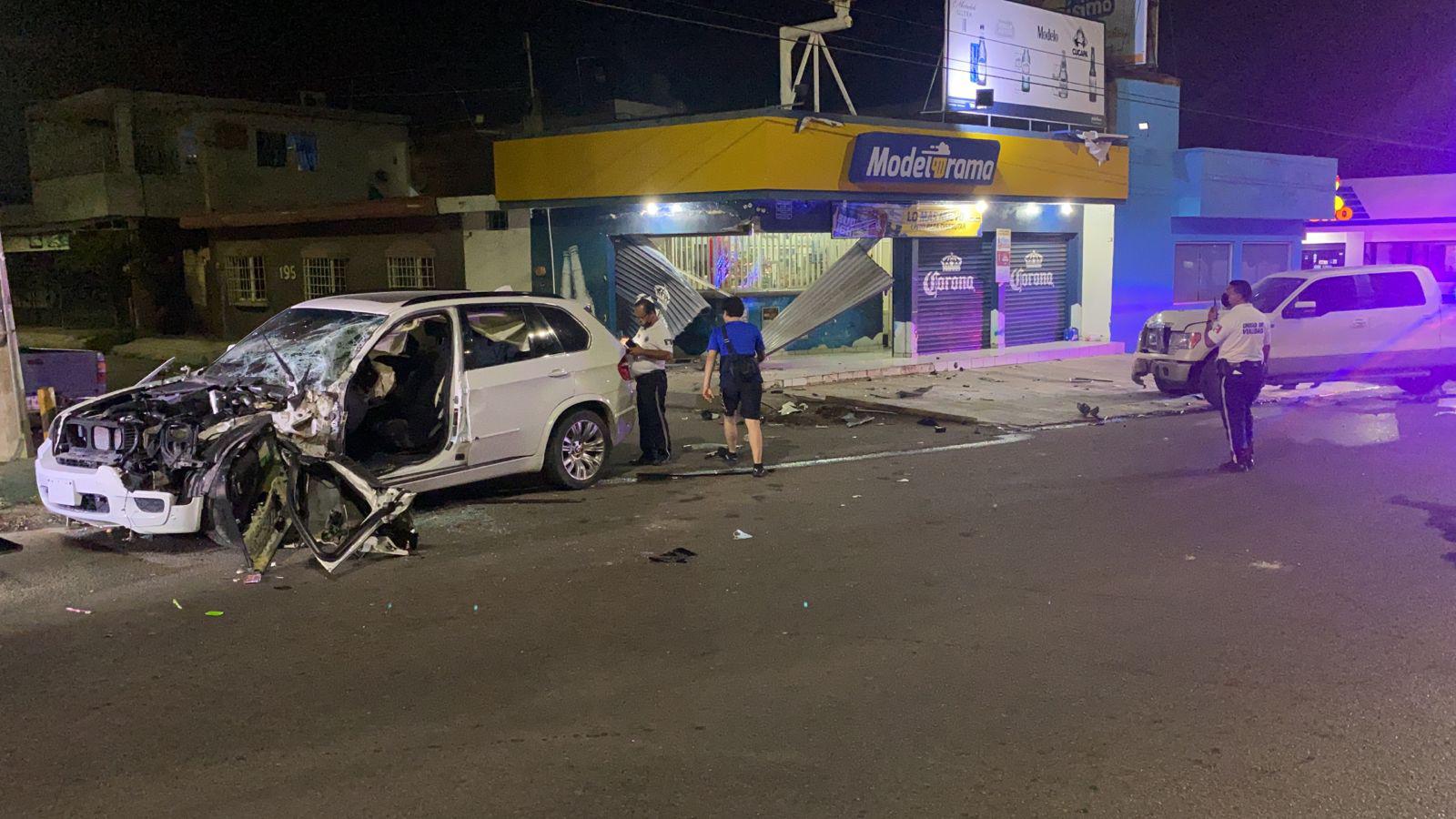 $!Camioneta de lujo choca unidad estacionada y termina estrellada contra expendio de cerveza en Culiacán