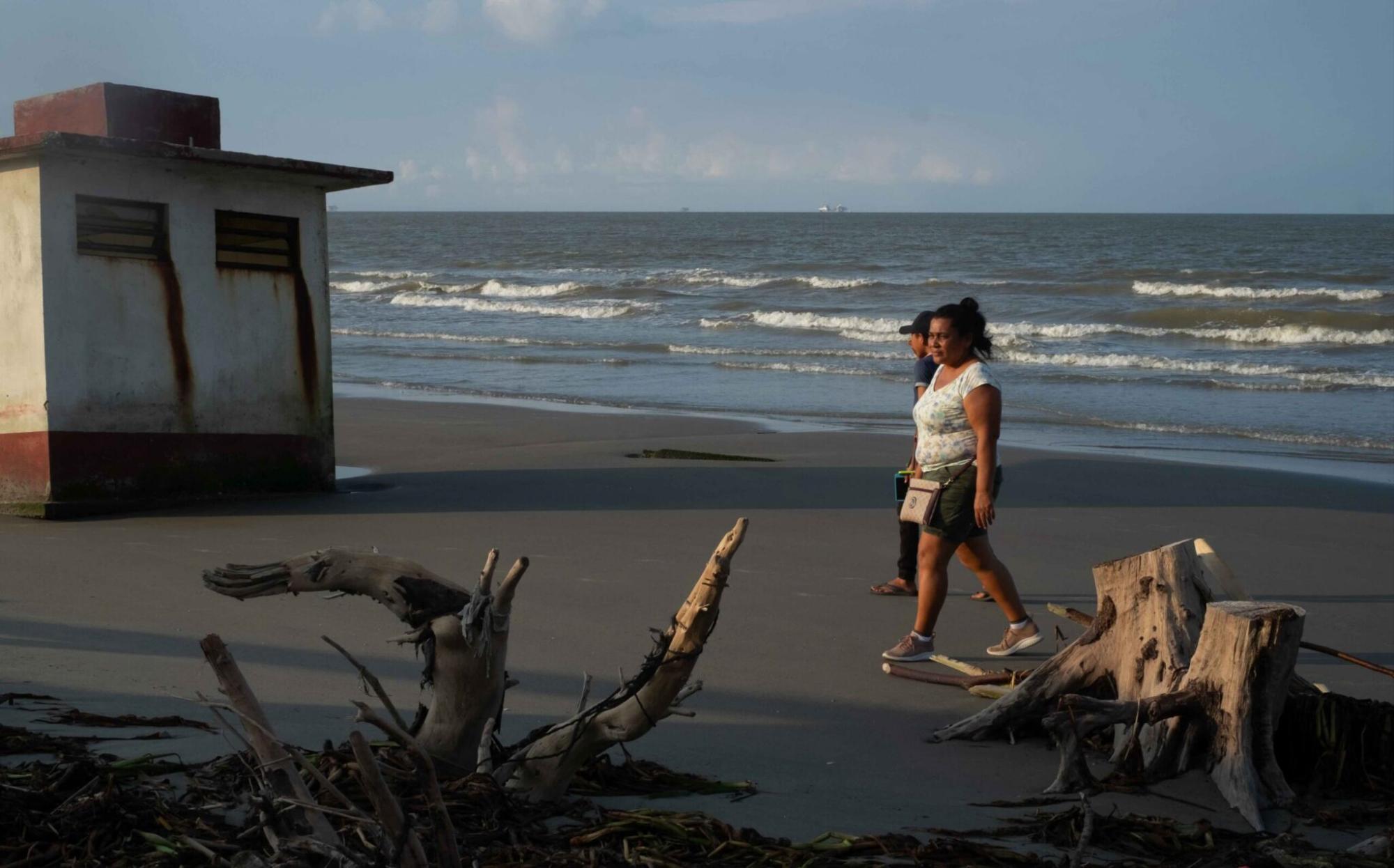 $!Guadalupe Cobos camina por la zona que ha sido erosionada por el mar en la comunidad de El Bosque.