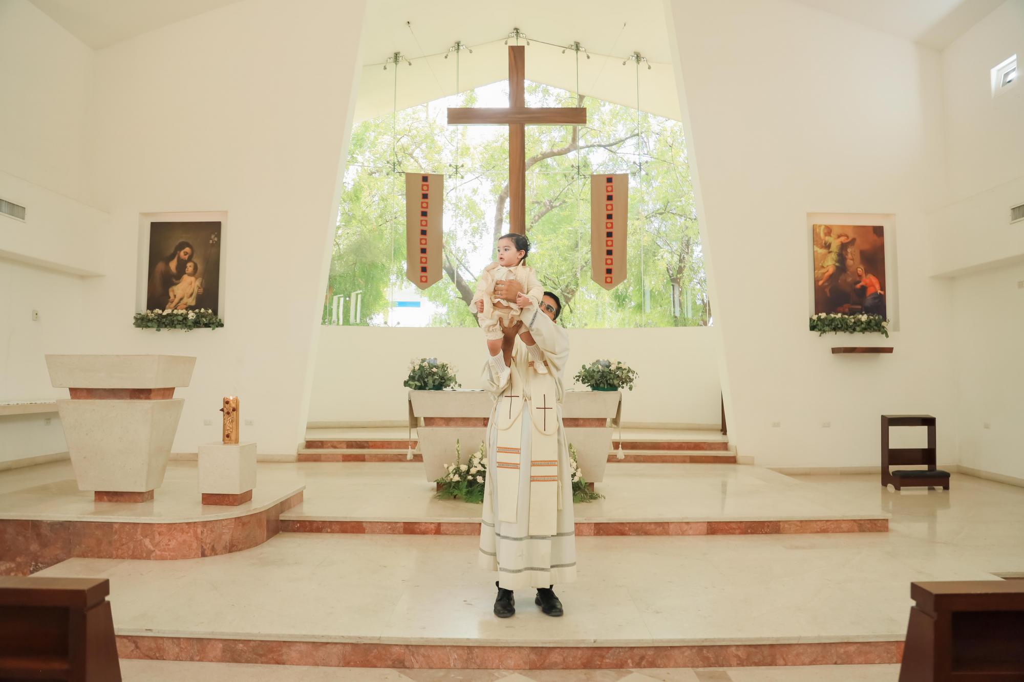 $!El sacerdote levanta a Fidel para mostrar que ya es hijo de Dios.