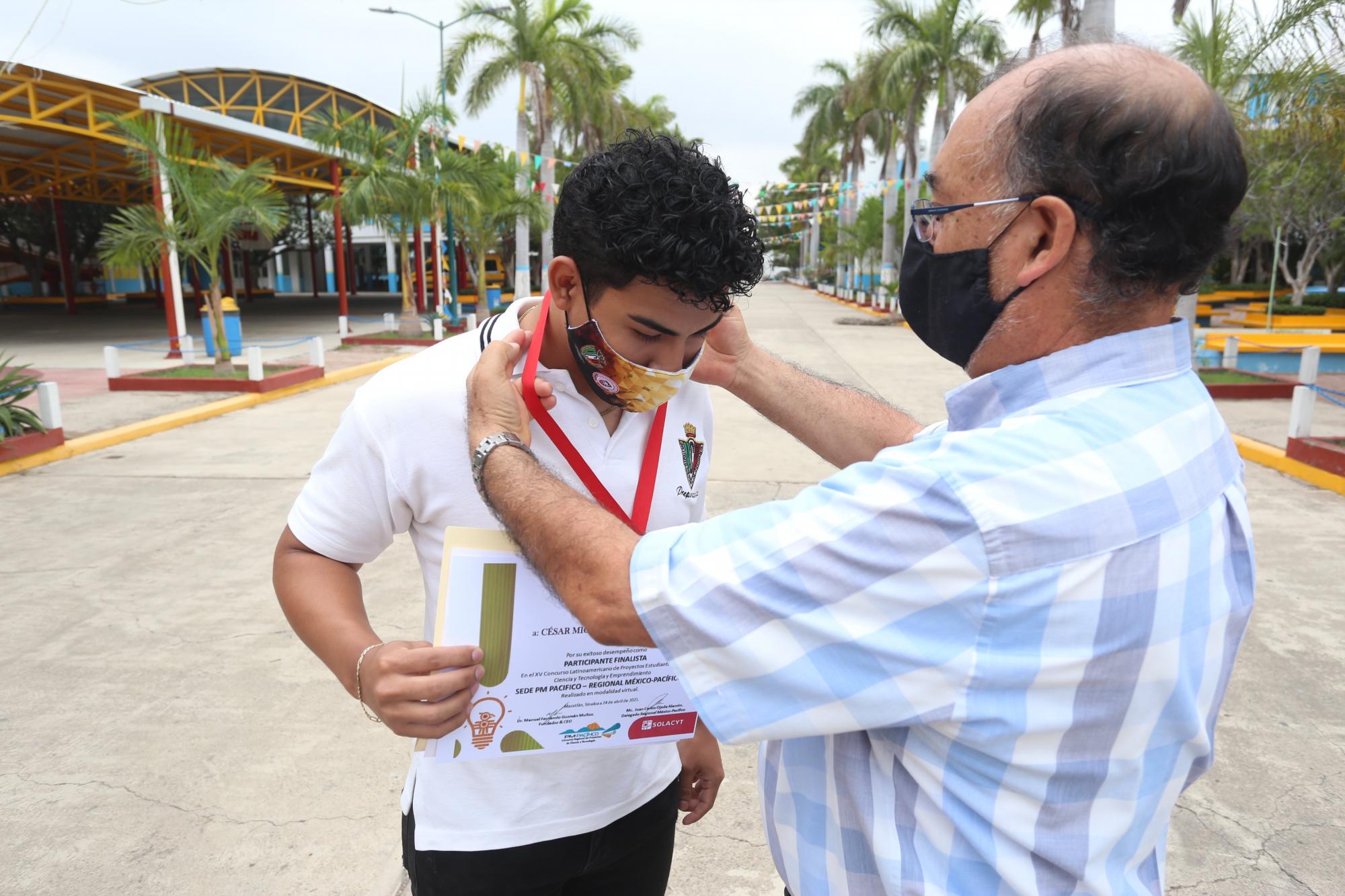 $!César Miguel Valencia Sosa recibe la medalla de manos del sacerdote xaveriano Gabriela Zavala Soria.