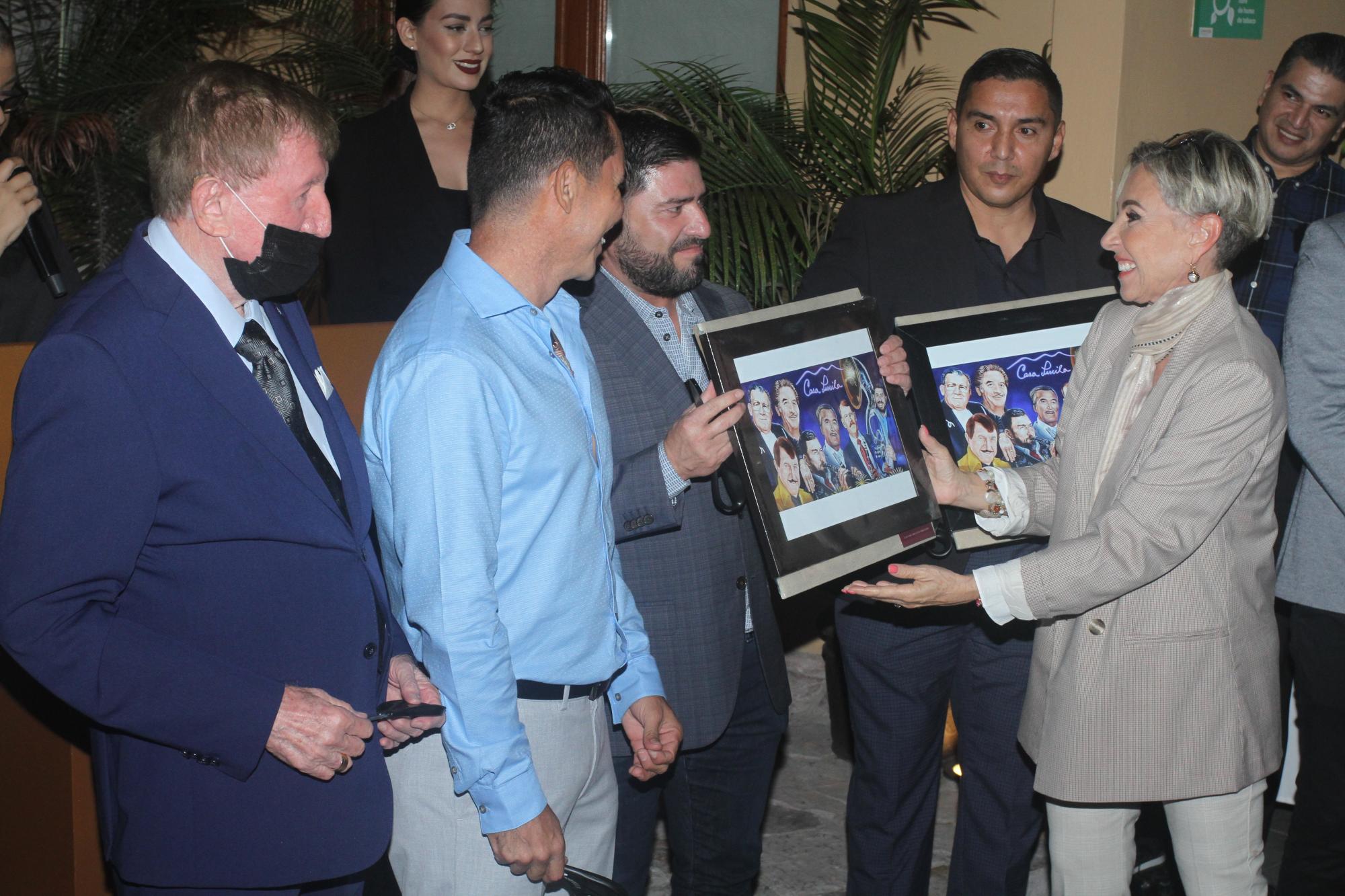 $!Sergio Lizárraga, líder de la Banda MS recibe una fotografía enmarcada del mural de manos de Mónica Coppel.