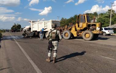 Elementos del Ejército y de la Guardia Nacional retiran vehículos que estaban sobre la carretera.