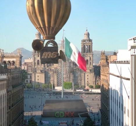 Un globo con el logo de la MS pasea por la Ciudad de México y se ve que desciende en pleno Zócalo capitalino para celebrar la Independencia de México.