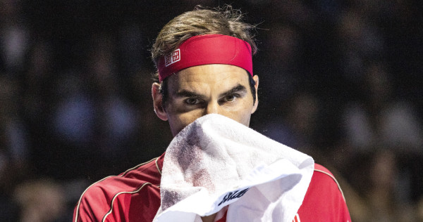 El tenista suizo Roger Federer se seca la cara durante un partido contra el griego Stefanos Tsitsipas.