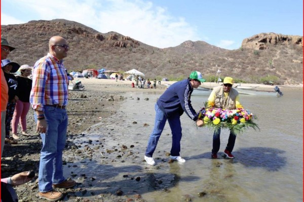 Organizadores y autoridades depositan una ofrenda floral, en la bahía de Navachiste.