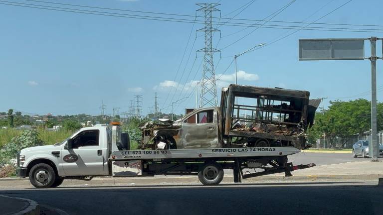 Uno de los vehículos incendiados es retirado de la avenida donde ocurrieron los hechos.