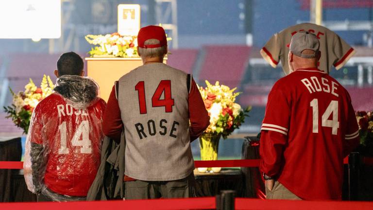 Aficionados usan casacas con el número de Pete Rose en los Rojos.