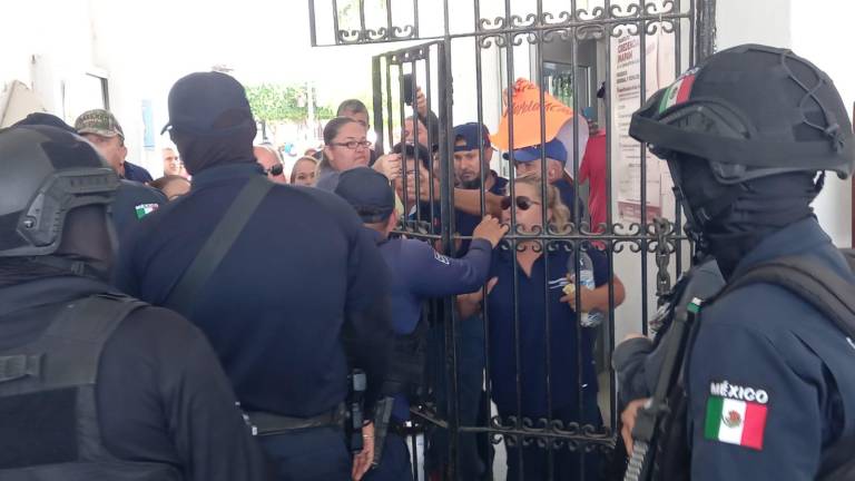 Manifestantes reclaman a policías municipales de Escuinapa al intentar cerrar la puerta del Palacio.