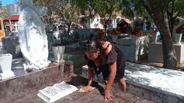 Velia Rosa y su hija Yesica Aracely llevaron flores y limpiaron la tumba de María del Socorro.