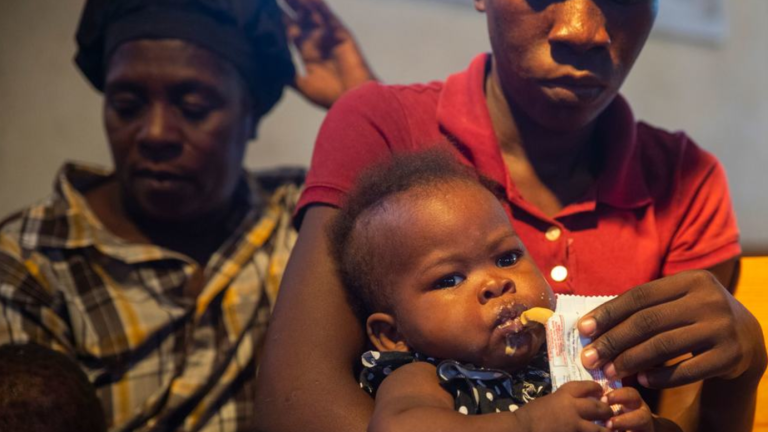 Un niño haitiano con desnutrición aguda grave tomando un suplemento nutricional.