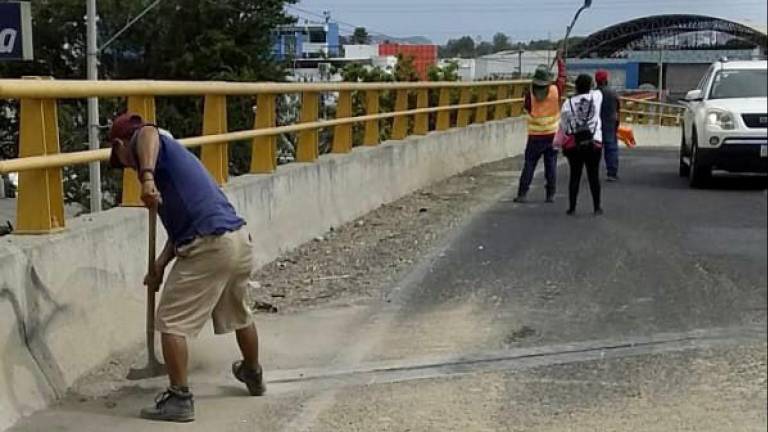 Trabajadores del Ayuntamiento retiran las piedras y tierra en el puente vehicular de ”La Corona”.