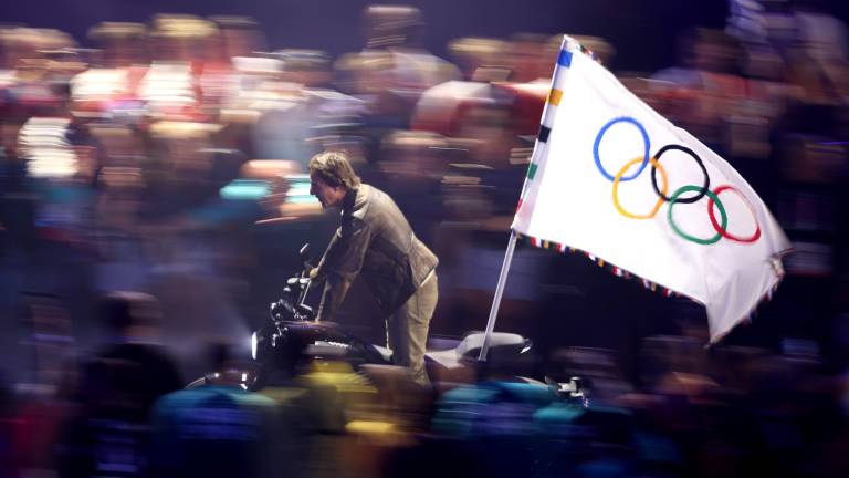 Tom Cruise bajó del techo del Stade de France para recoger el emblema de los cinco aros olímpicos.