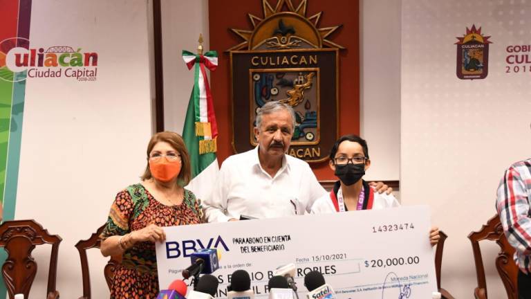 Carlos Emilio Báez muestra su cheque simbólico.