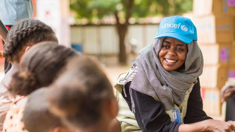 Una trabajadora de UNICEF habla con niños desplazados en un punto de encuentro en Madani, en el centro-este de Sudán.