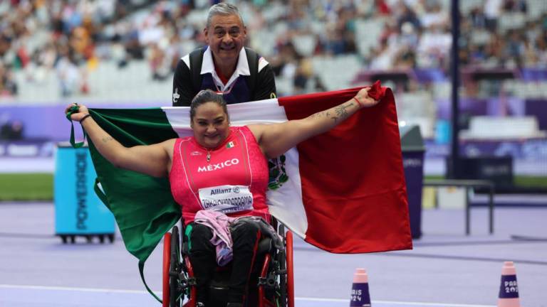 Gloria Zarza festeja su medalla de oro con la bandera mexicana.