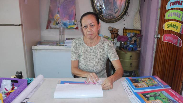 Lucía, con paciencia, en el regreso a clases hace del forrado de libros un oficio