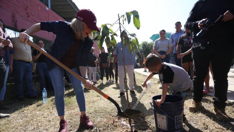 La Alcaldesa Estrella Palacios Domínguez y un niño plantan árboles en la comunidad de Siqueros.