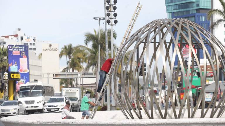 Trabajadores del Ayuntamiento asean el monumento a la ‘Perla del Pacífico’.