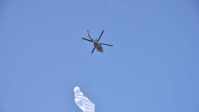 Helicóptero con bandera blanca sobrevuela Culiacán; es una práctica del Ejército para la inauguración del beisbol