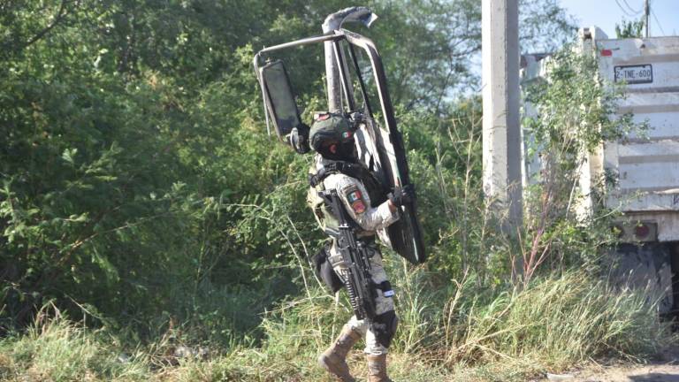 Un militar retira una de las partes del camión que bloqueaba la carretera.