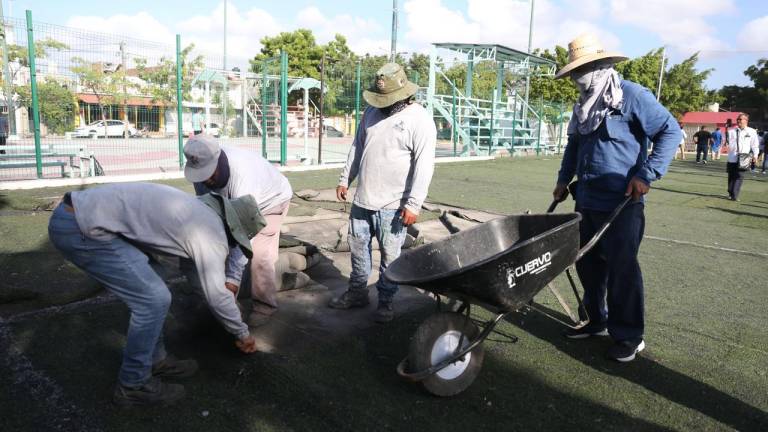 Trabajadores del Ayuntamiento, durante el reempastado de la cancha de Casa Hogar.