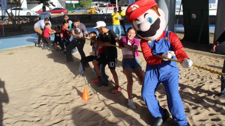 Mario Bros ayuda a los niños a jalar la cuerda.