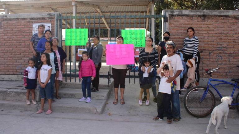 Padres de familia y sus hijos protestan en la puerta del kínder Esthela Ortiz de Toledo, en demanda de que los baños de la institución sean reparados.