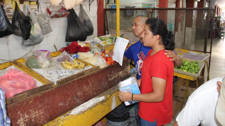 La judoca y su entrenador visitan los locales del mercado “Miguel Hidalgo” en busca de recursos.