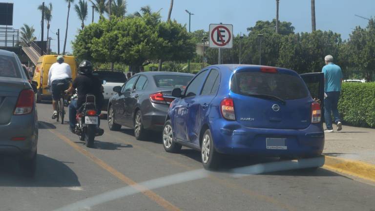 Varios vehículos estacionados sobre el carril preferencial, afuera del IMSS nuevo.