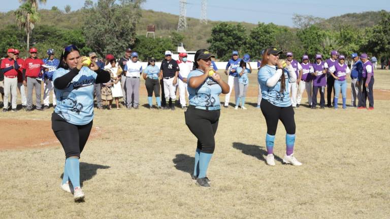 Las hermanas homenajeadas en softbol lanzan la primera bola.