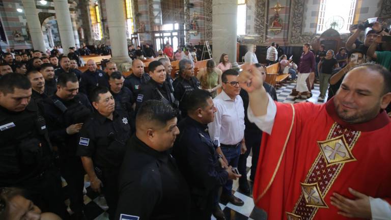 El Padre Adán Pasos Sánchez le da la bendición a policías municipales, en una celebración eucarística por el Día del Policía, en la Catedral de Mazatlán, el pasado 29 de junio.