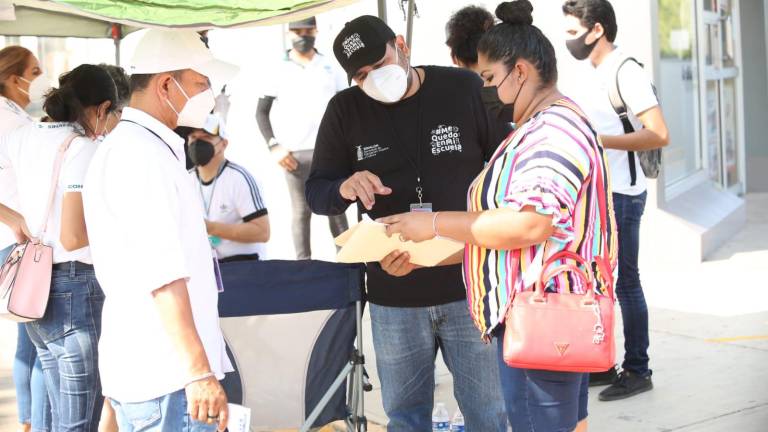 Una docente recibe información sobre la mecánica de la vacunación.