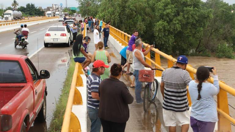 Habitantes de Villa Unión acuden al puente a ver la creciente del Río Presidio