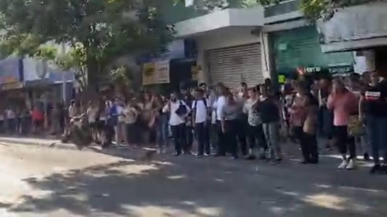 En calles del Centro de Culiacán usuarios del transporte público esperan la llegada de camiones.