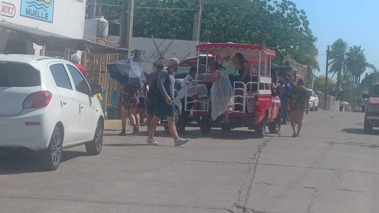 Un grupo de turistas llegan al embarcadero de los catamaranes.