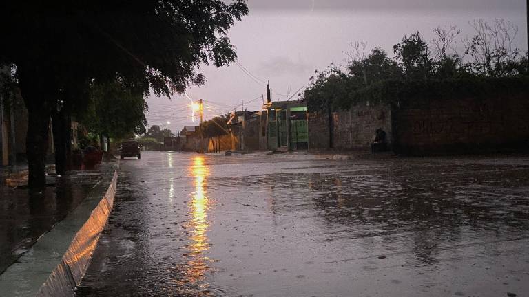 Un rayo ilumina las calles en una noche de lluvias y viento.