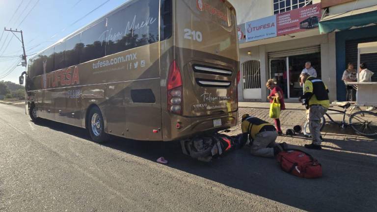 La menor y la motocicleta quedaron bajo el autobús.