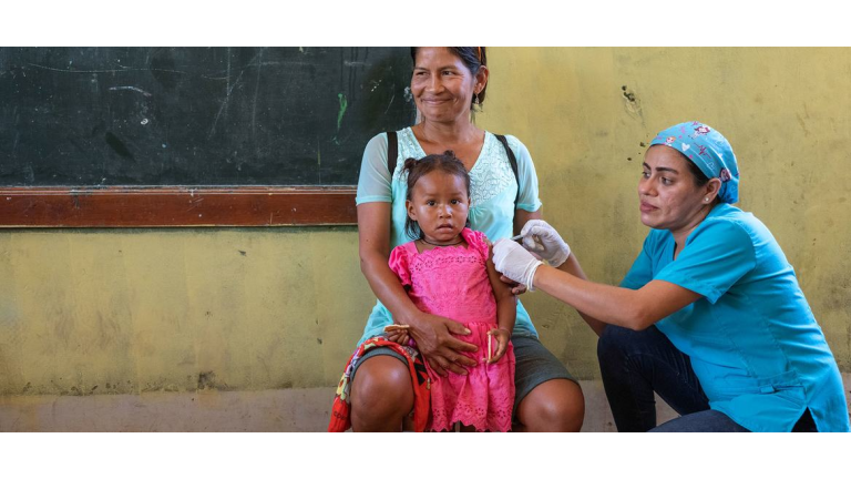 Una niña de dos años recibe la vacuna contra la gripe en un dispensario móvil de Loreto, Perú.